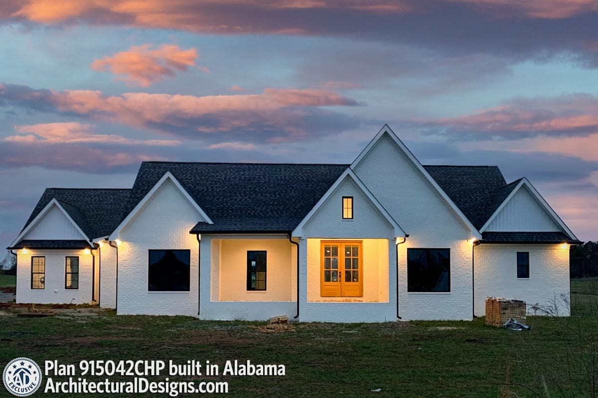 Modern Farmhouse house plan exterior with white brick, gabled rooflines, a covered entry with double doors, and prominent dormers.