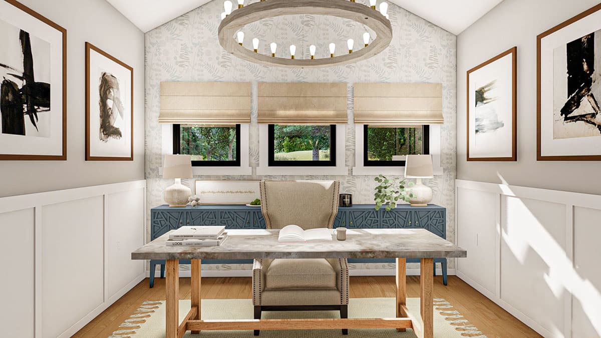 Home office with wainscoting, abstract art, a desk with a chair, and three windows.