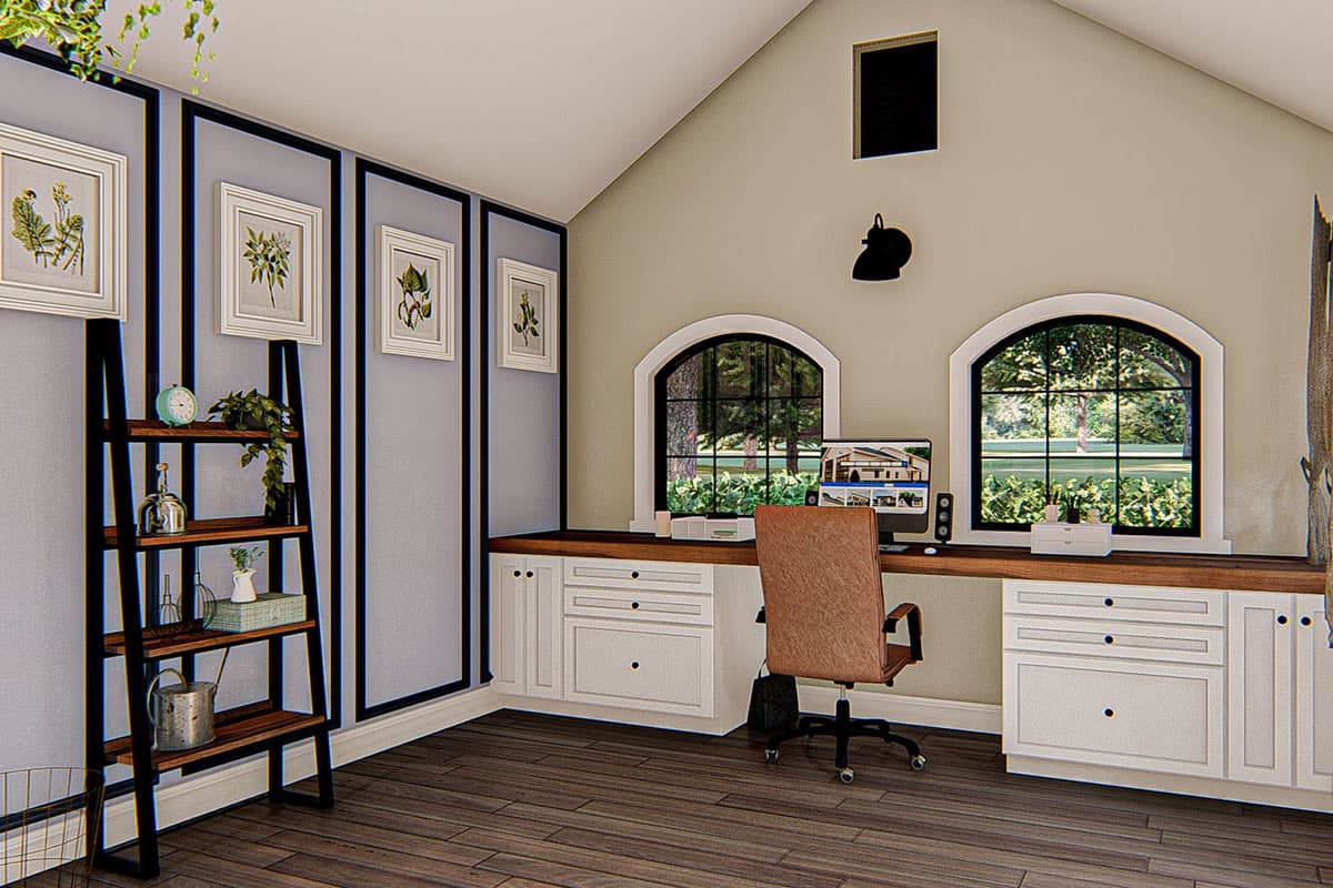 Interior view of a home office with a desk, computer, chair, built-in cabinetry, and arched windows.