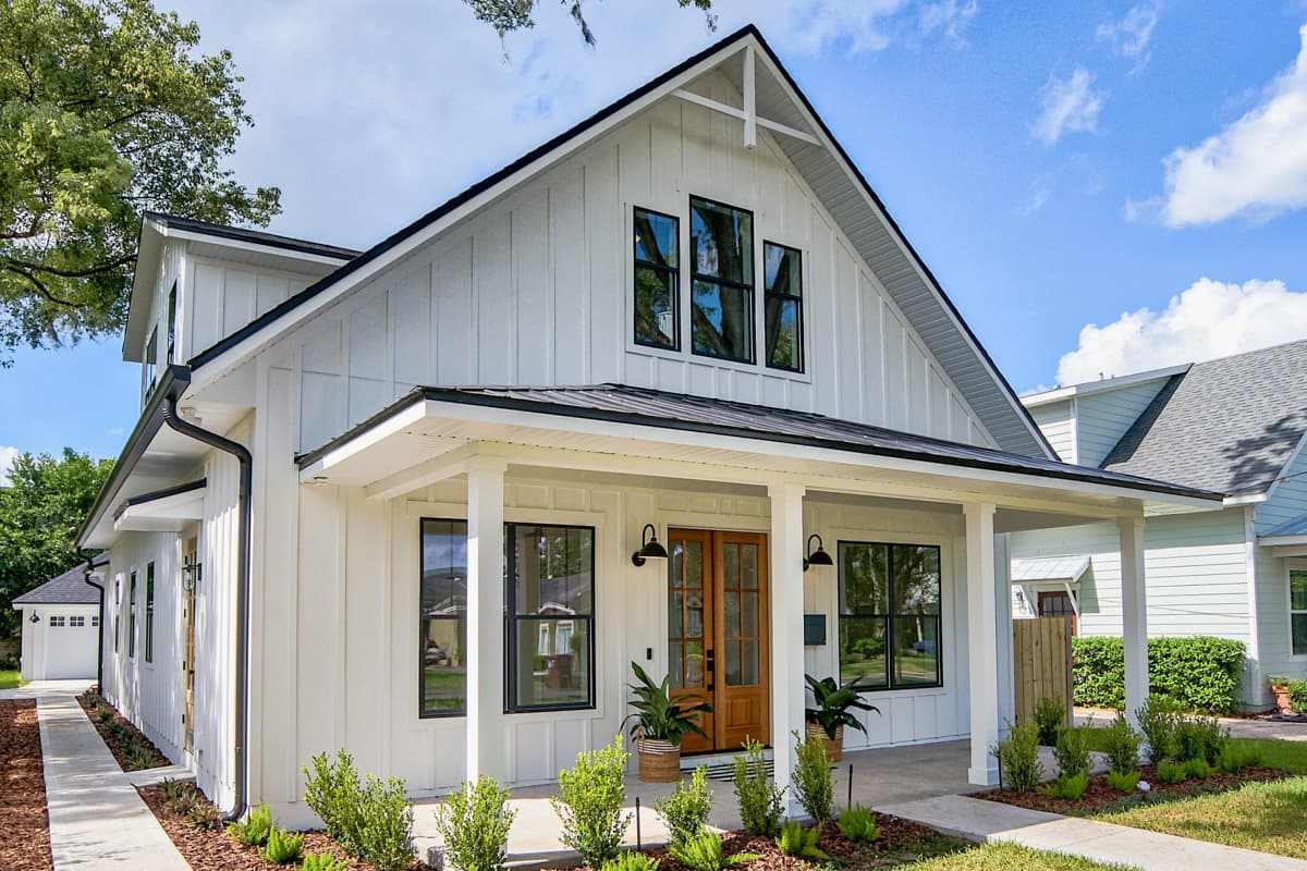 Modern Farmhouse house plan exterior with a gabled roof, covered porch, and board-and-batten siding. Features include multiple black-framed windows.