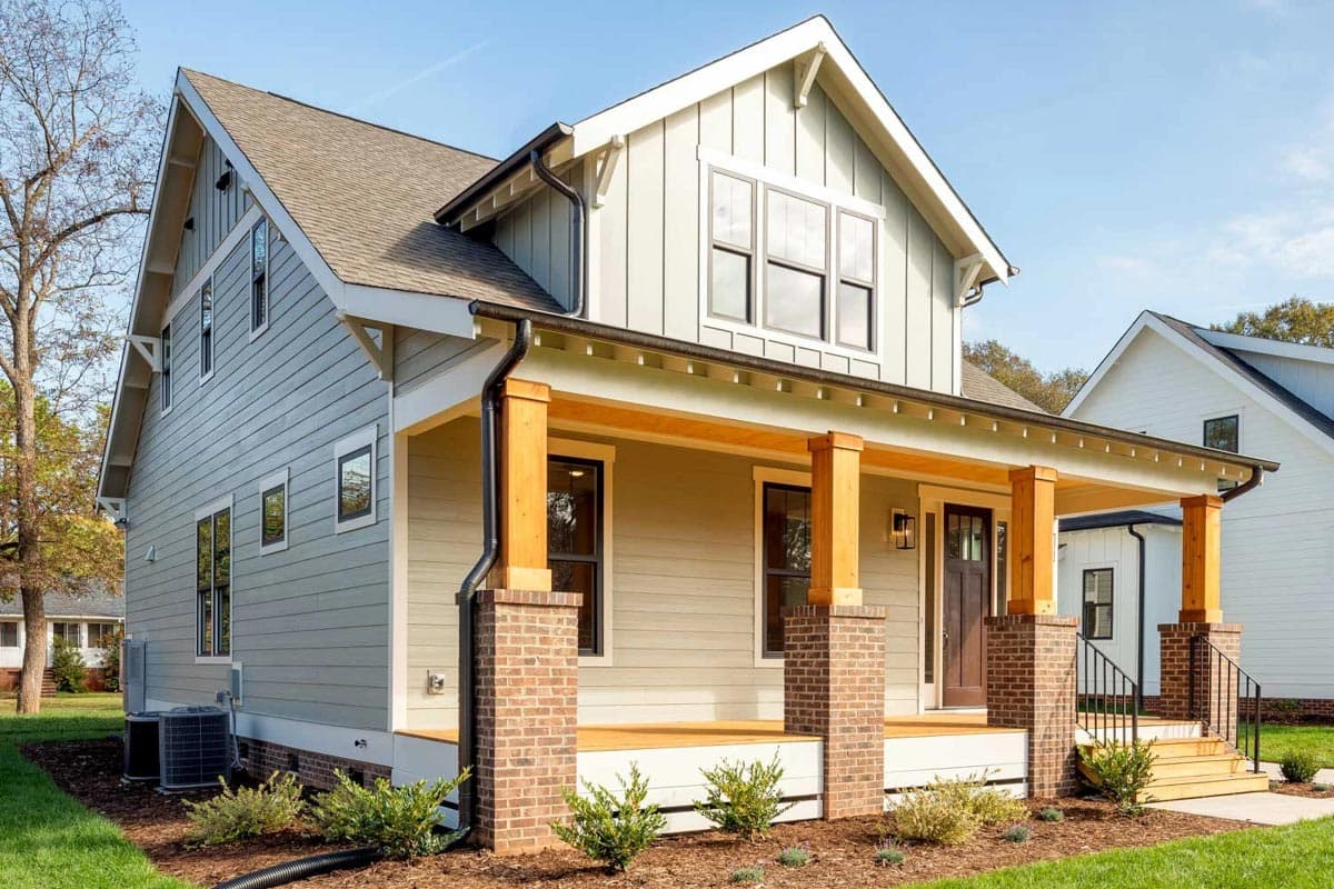 Modern Farmhouse house plan exterior with a covered porch, brick piers, timber posts, and multiple gables.