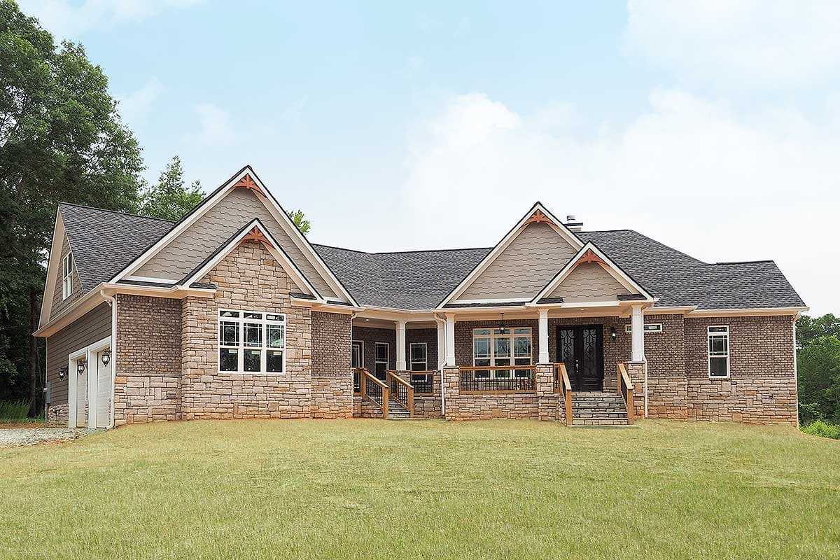 House plan exterior with brick and stone facade, covered porch with columns, multiple gables, and a two-car garage.