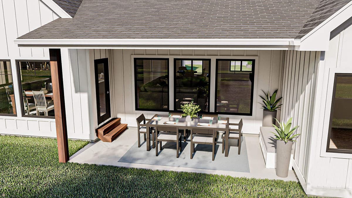 Modern Farmhouse house plan exterior with covered patio, dining set, and large windows.