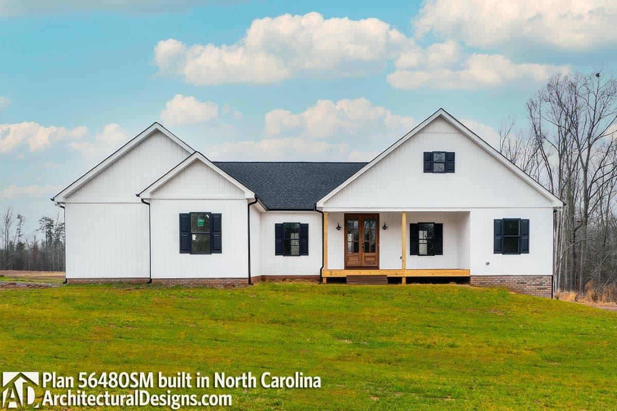 Modern Farmhouse style house plan exterior with white board and batten siding, gables, and a covered front porch with wood detailing.