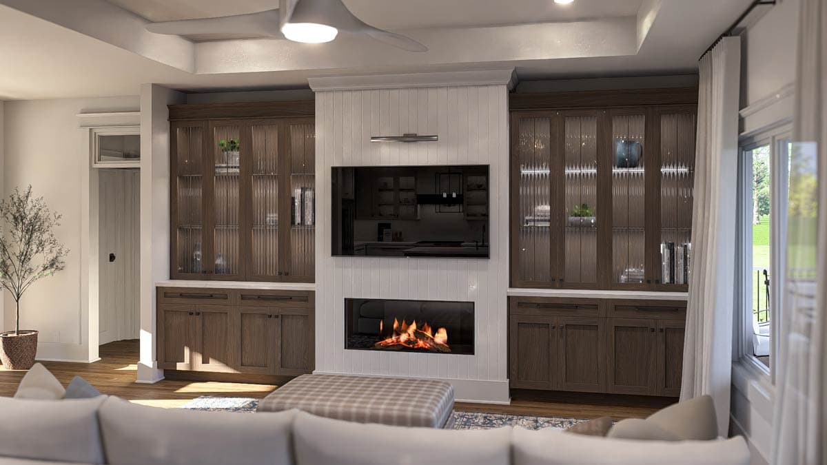 Living room with fireplace, mounted TV, built-in cabinetry with fluted glass doors, and a tray ceiling.