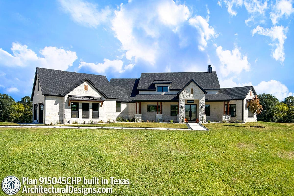 House plan exterior with white brick, stone accents, multiple gables, and covered porch.