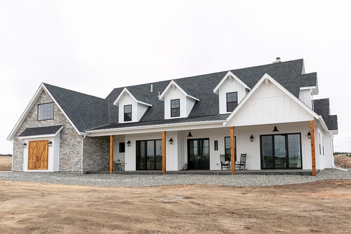 Modern Farmhouse house plan exterior with stone accents, covered porch, dormers, and board-and-batten siding.