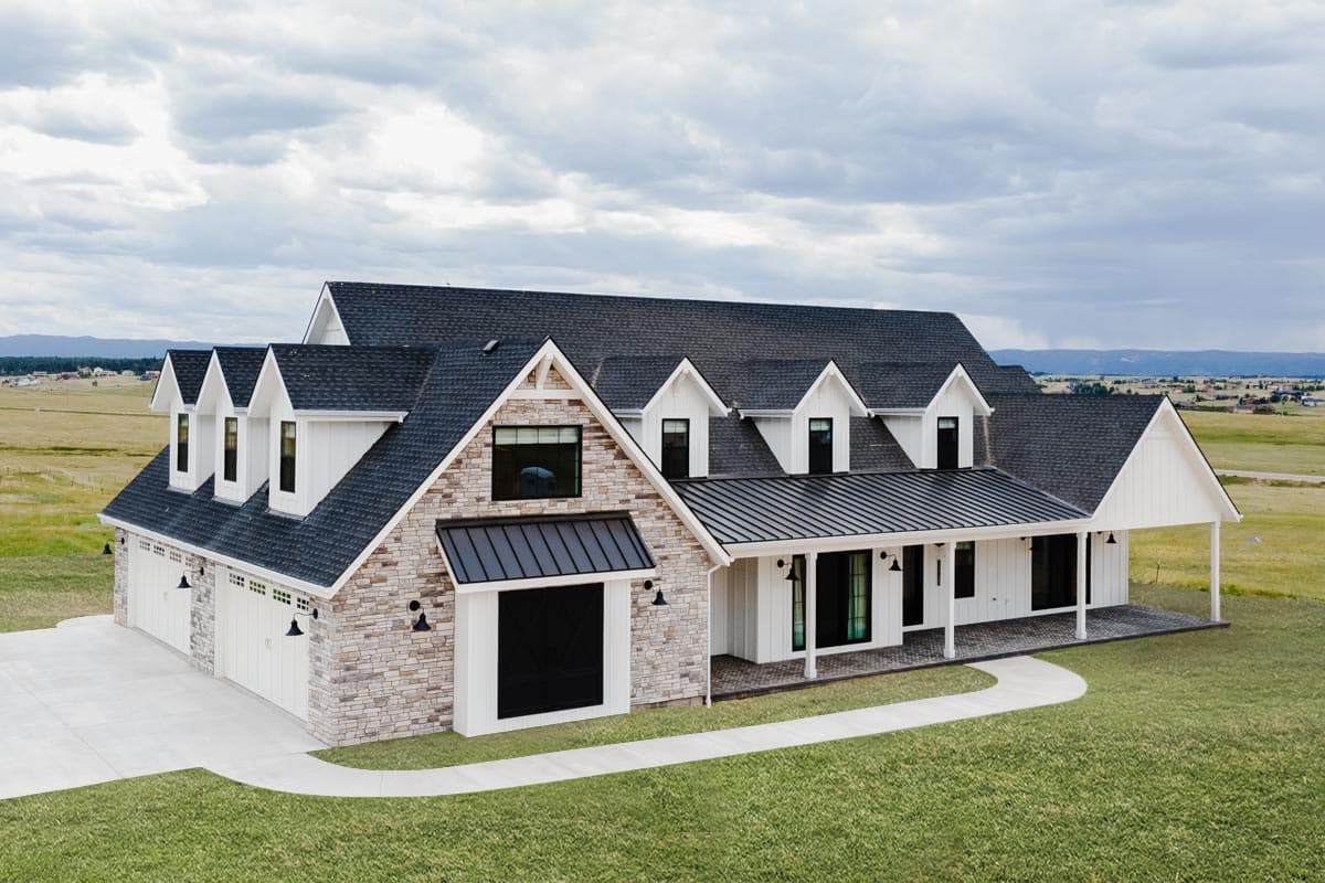 Modern Farmhouse house plan exterior with a wrap-around porch, multiple gables, dormers, stone accents, and a four-car garage.