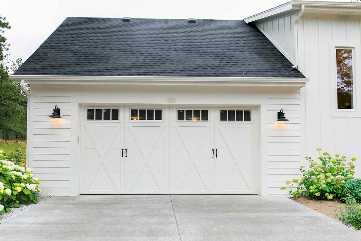 Modern Farmhouse house plan exterior: two-car garage with X-panel doors, transom windows, and board-and-batten siding.