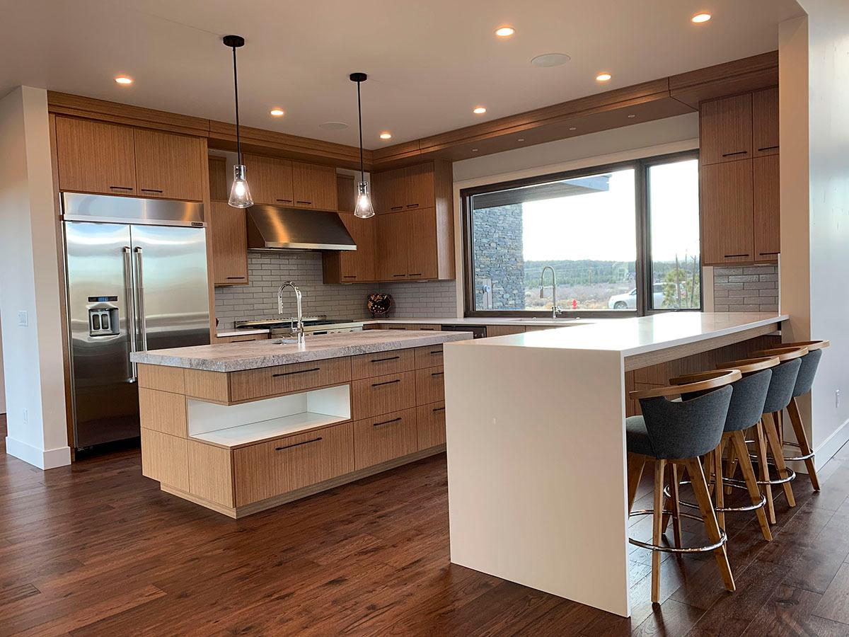 Modern kitchen with dual islands, sleek cabinetry, stainless steel appliances, and large picture window.