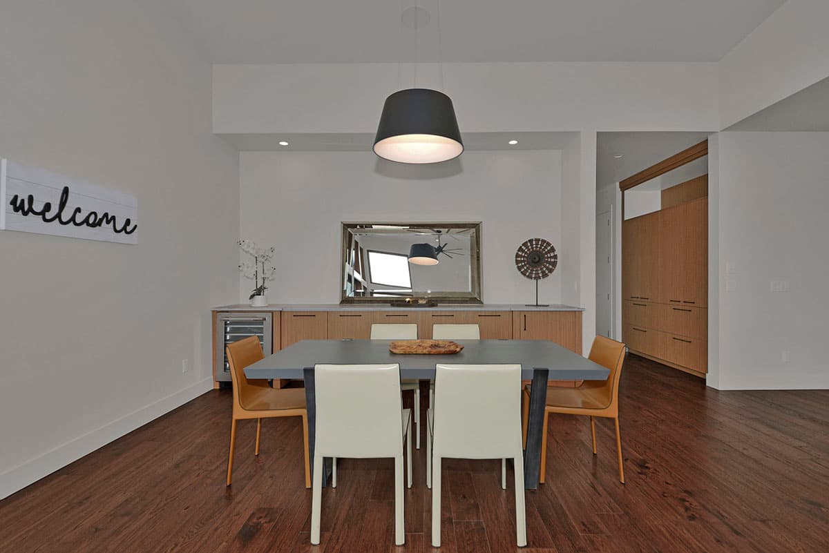 Dining room with a table, chairs, built-in cabinetry, wine fridge, and large mirrored wall.