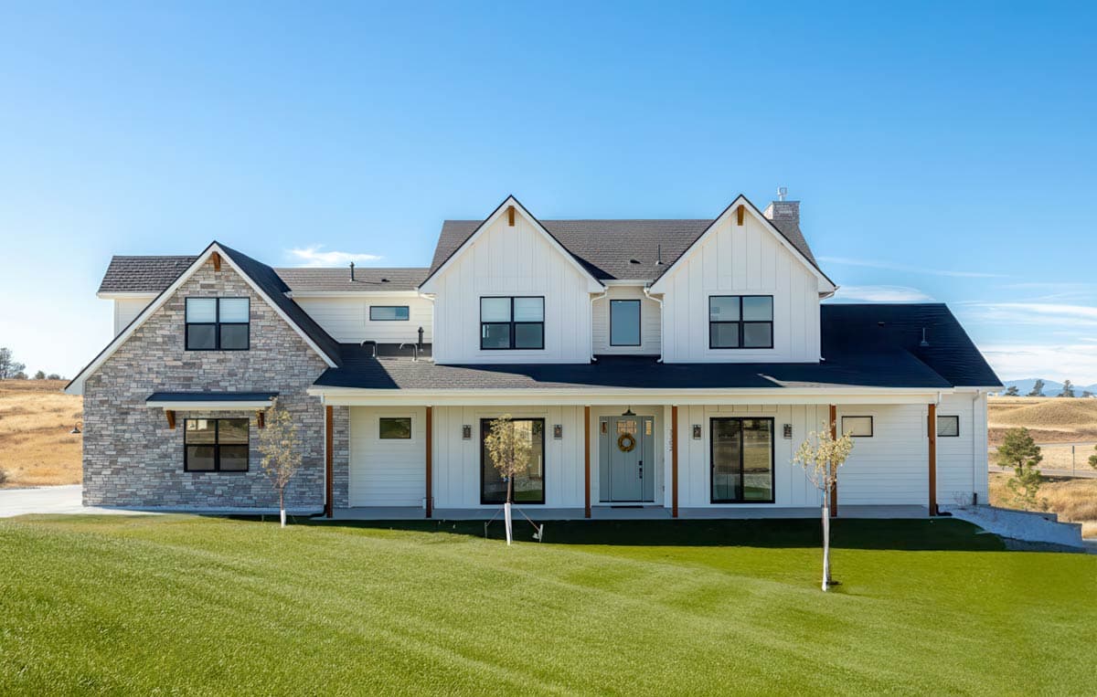 House plan exterior. Two-story Modern Farmhouse with gabled roof, stone facade accent, and covered porch with exposed beams.