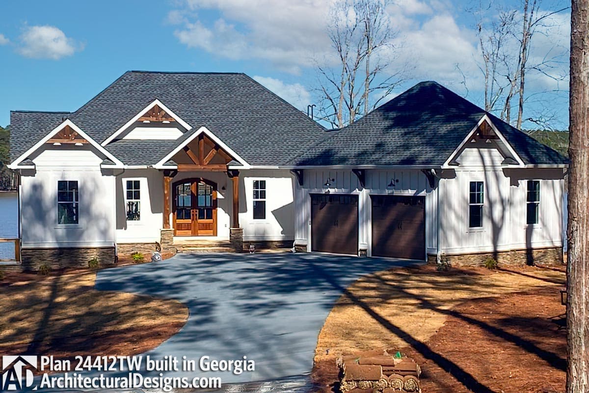 House plan exterior: Modern Farmhouse, one story, covered entry with wood beams, triple garage doors, multiple gables.