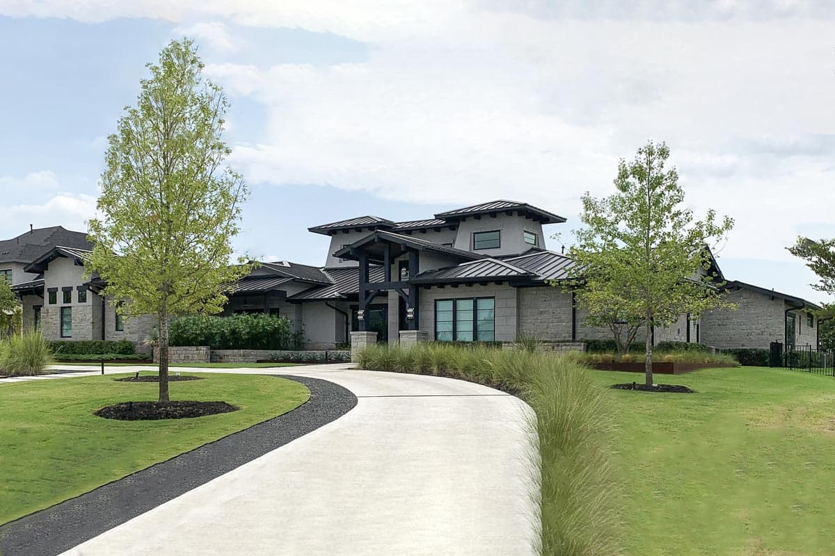 House plan exterior. Modern style, single story, with a covered entry, multiple rooflines, and dark metal roofing.