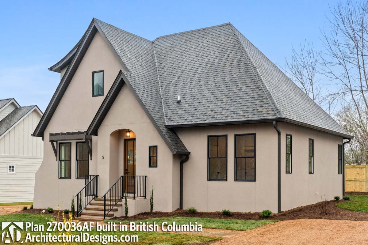 House plan exterior view of a two-story modern home with a prominent gable, arched entry, and dark-framed windows.