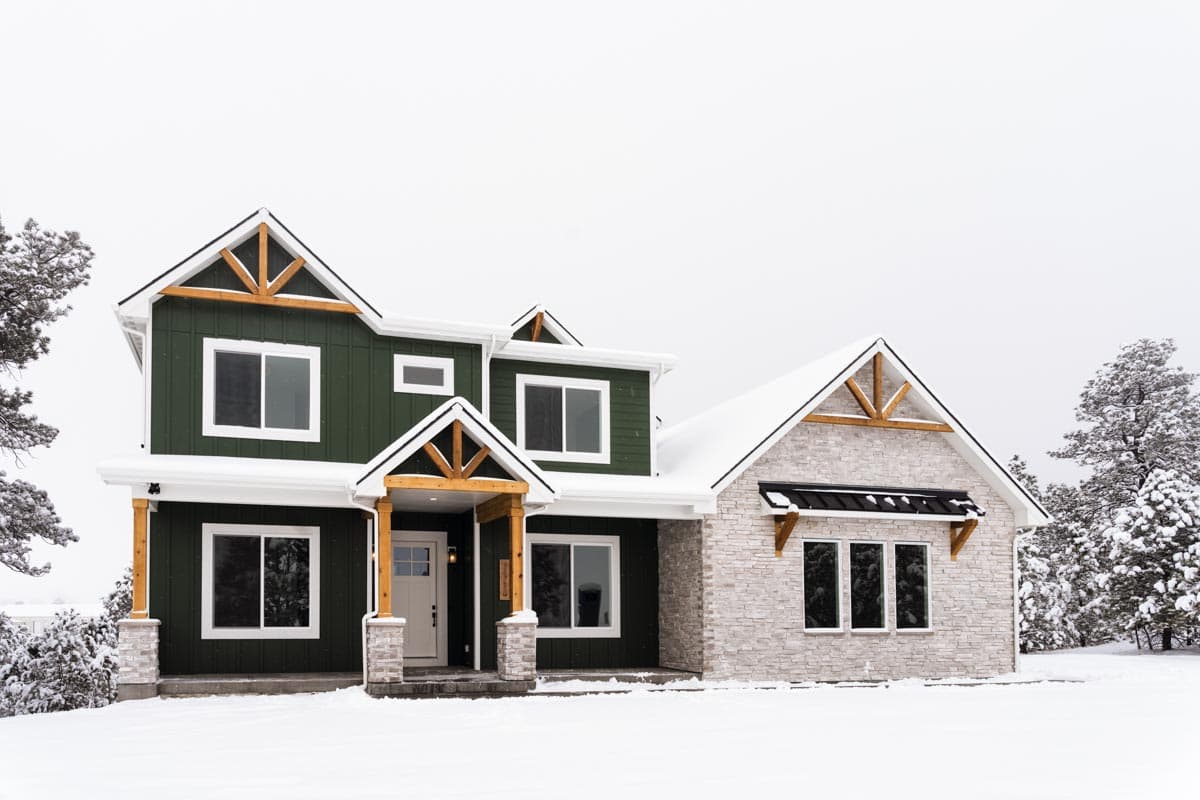 House plan exterior: Two-story Modern Farmhouse with green siding, stone accents, exposed wood beams in gables, and covered entry.