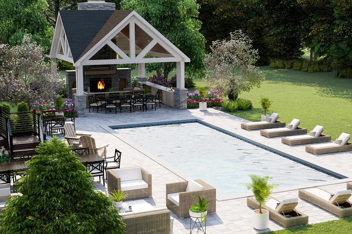 Outdoor living area with covered pavilion, fireplace, bar, dining table, pool, and lounge chairs.