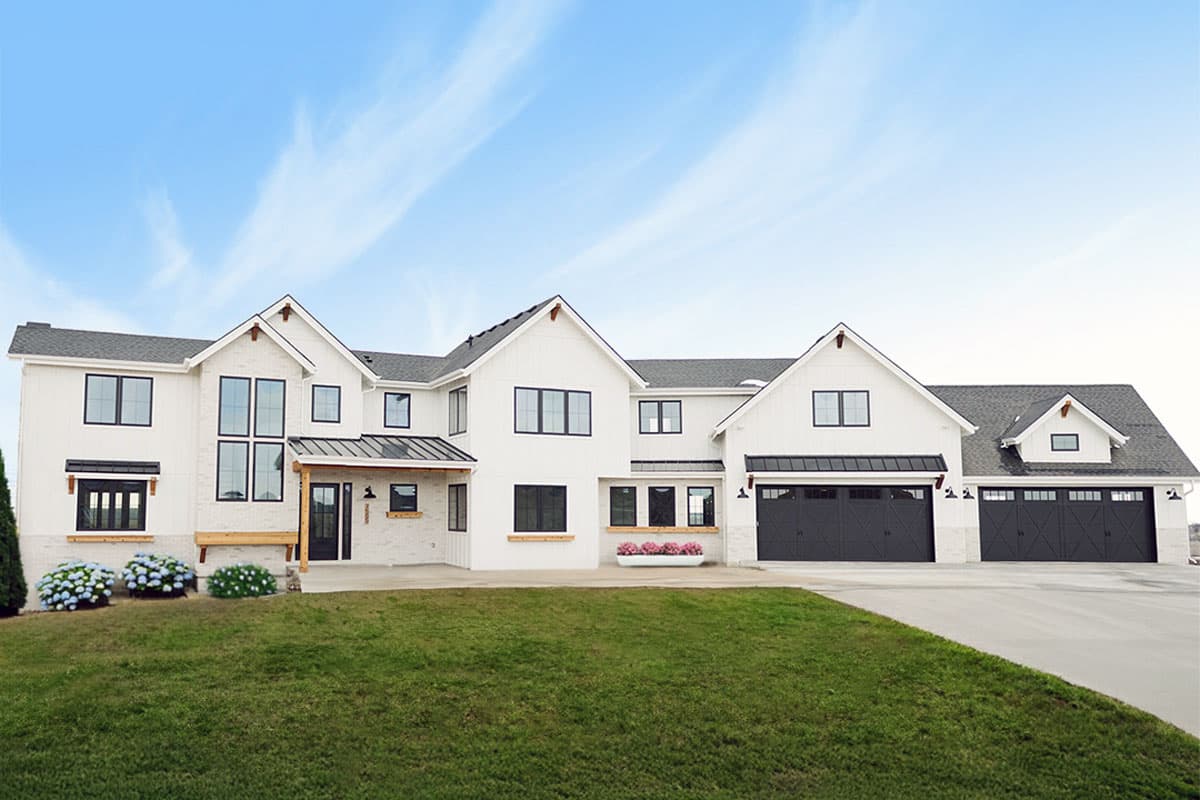 House plan exterior. Two-story Modern Farmhouse with gables, a covered porch, and a three-car garage.