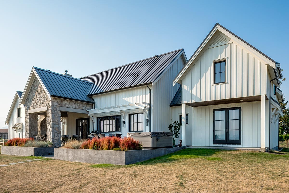 Modern Farmhouse style house plan exterior with stone accents, metal roof, gables, and covered porch.