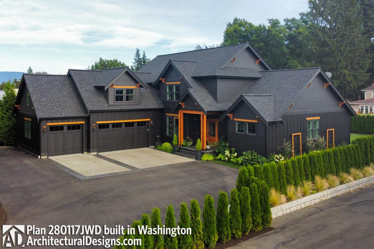 House plan exterior: Modern Farmhouse style, two stories, dark siding, gabled rooflines, three-car garage, and wood accents.