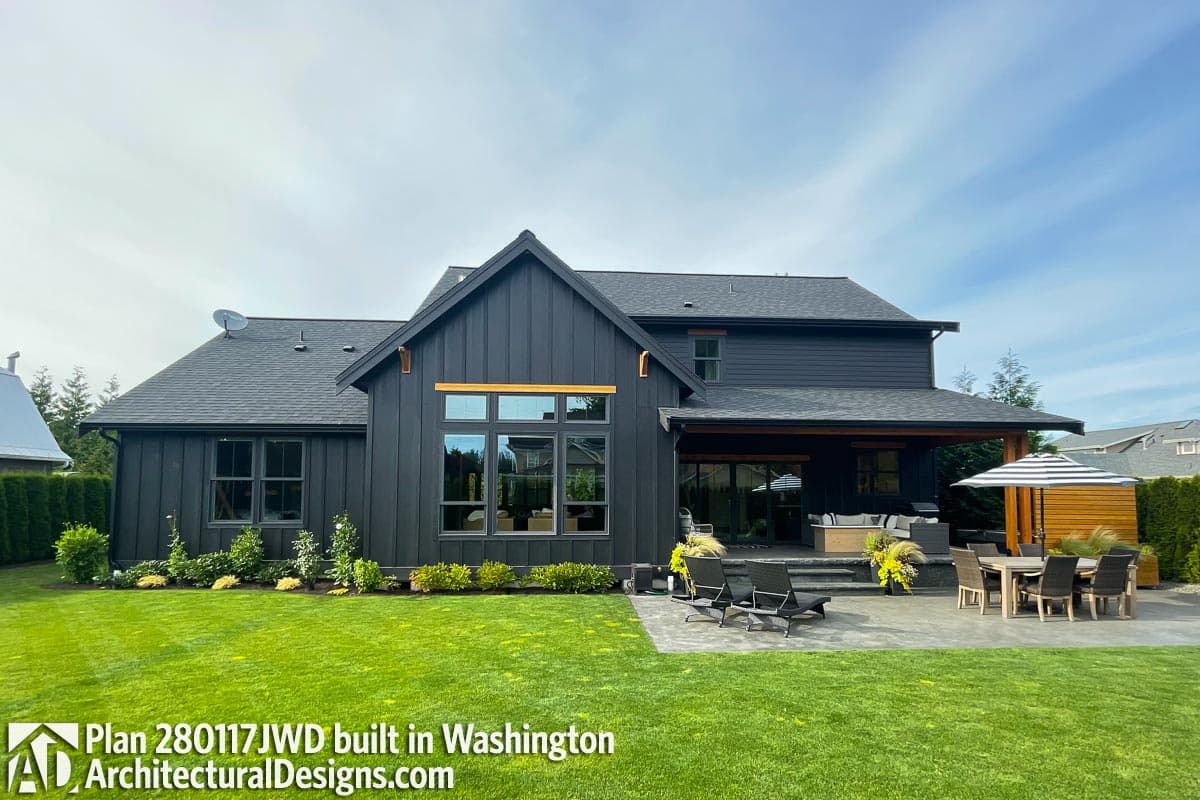 Modern Farmhouse house plan exterior with dark vertical siding, gable roof, large windows, and covered patio.