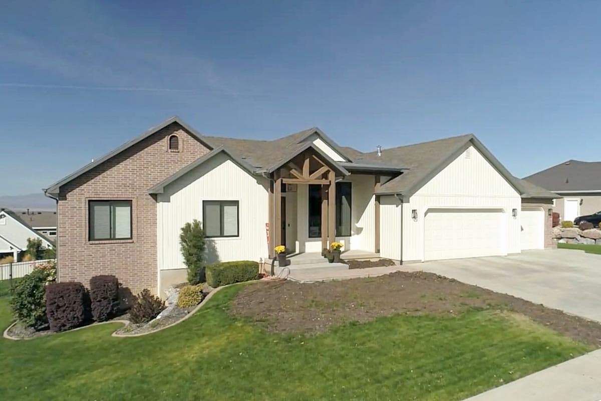 Modern Farmhouse house plan exterior with brick accents, prominent gabled roof, and timber-framed entry porch.