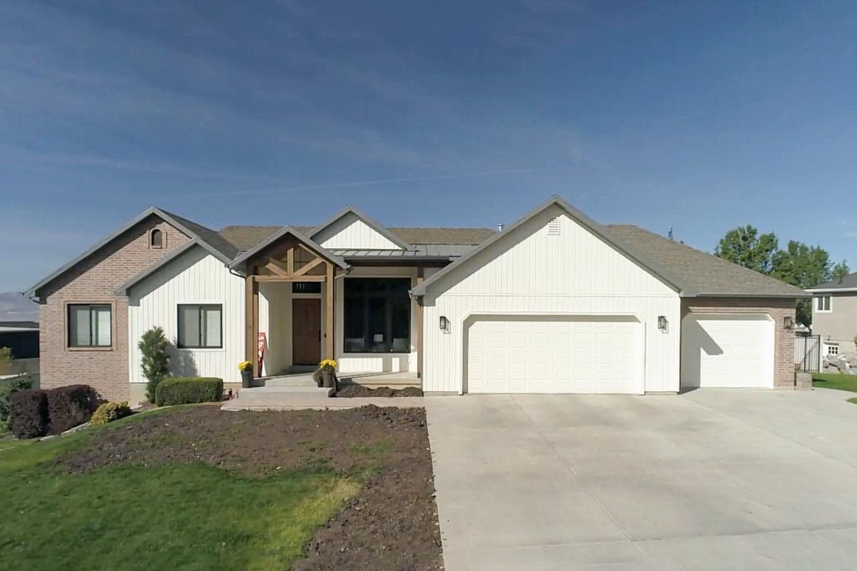 House plan exterior of a single-story Modern Farmhouse with a prominent wood-trimmed entrance, gabled rooflines, and a three-car garage.