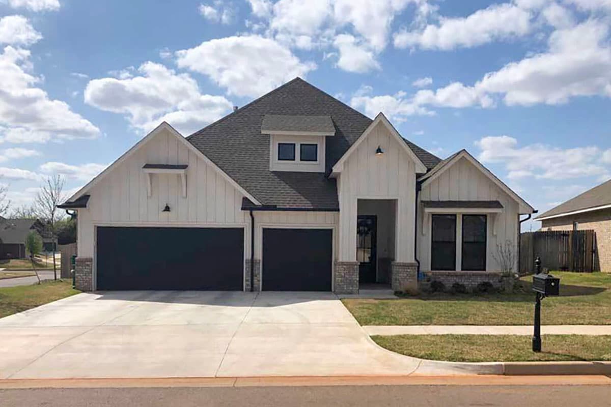 House plan exterior: Modern Farmhouse style, one-story, with a three-car garage, prominent gables, and a dormer.