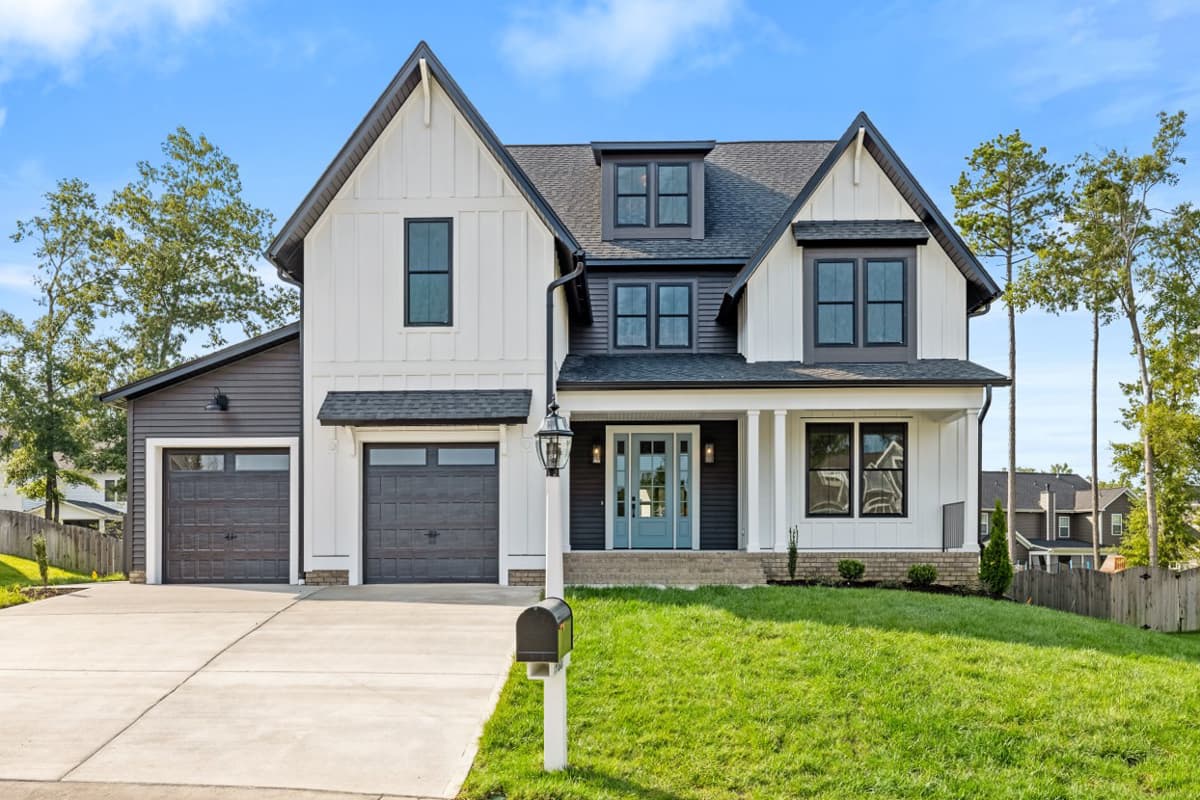 House plan exterior view of a two-story Modern Farmhouse with gables, a covered front porch, and a side-entry garage.