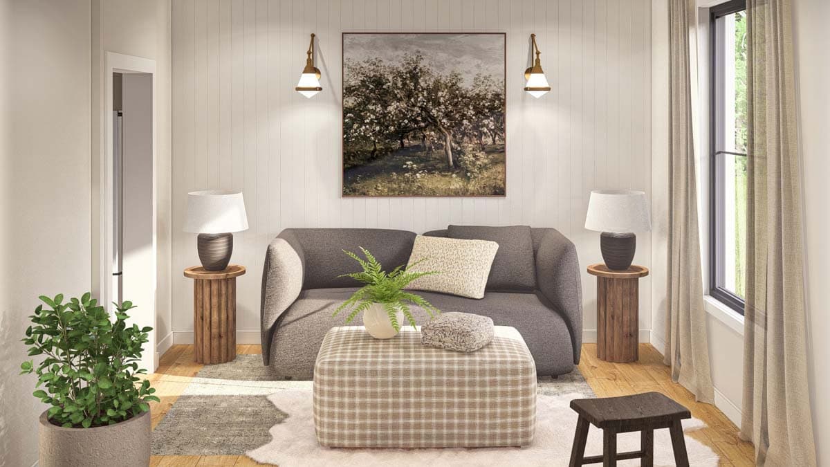 Living room with grey sofa, plaid ottoman, two side tables with lamps, large window, and artwork.