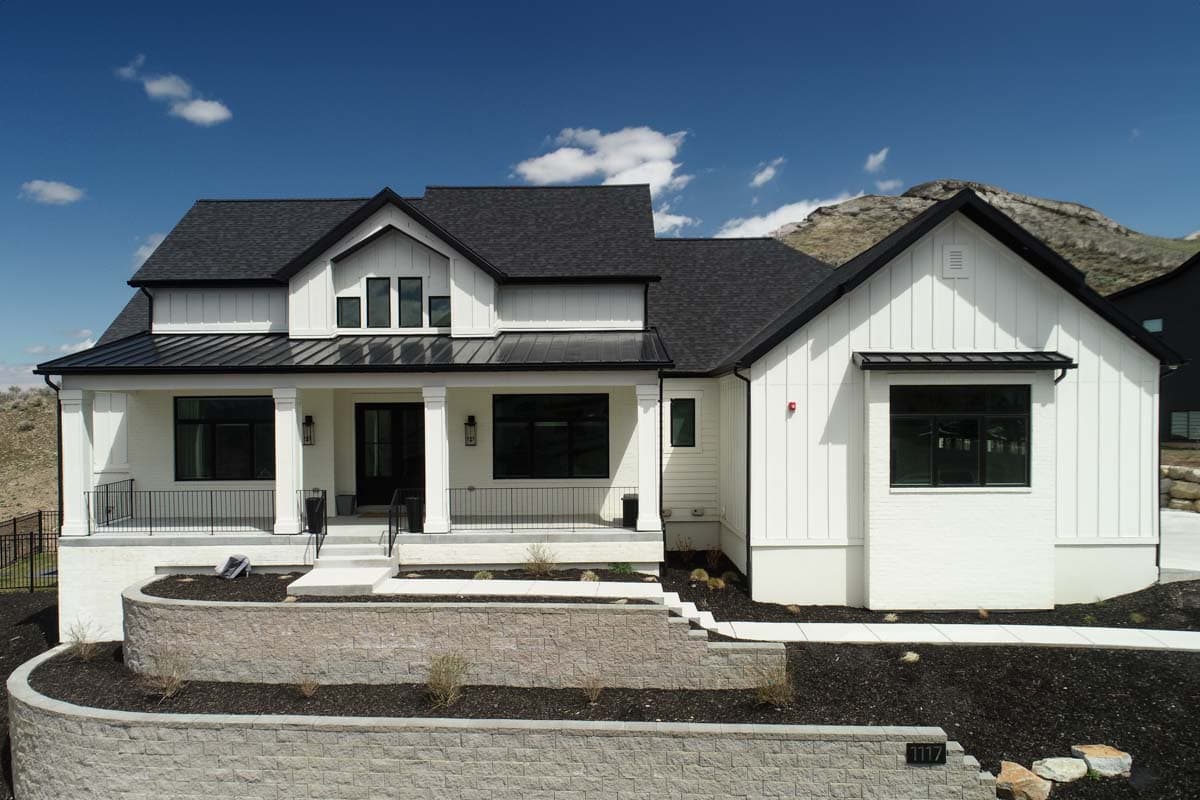 Modern Farmhouse house plan exterior with a covered porch, metal roof, board and batten siding, and multiple gables.