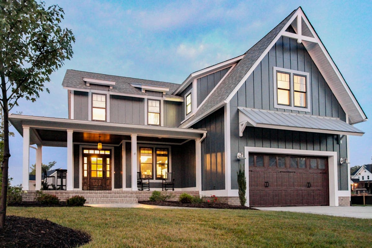 House plan exterior: Two-story Modern Farmhouse with a wraparound porch, gables, dormers, and attached garage.