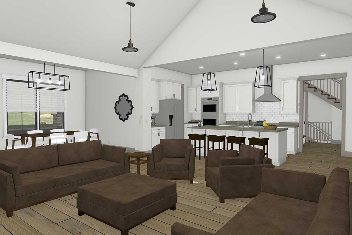 Open-concept living area with vaulted ceiling, showing a great room, dining area, kitchen with island, and stairs.