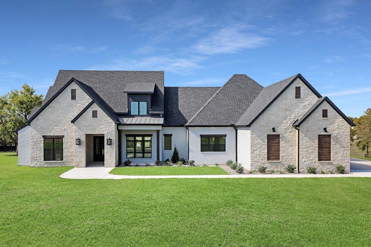 House plan exterior. Two-story Modern Farmhouse with gables, dormers, and stone facade with dark trim. Features a covered entry.