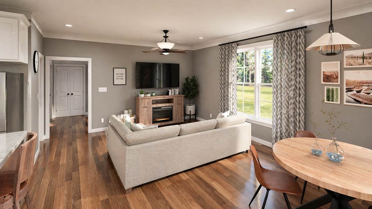 Open-concept living area with L-shaped sofa, electric fireplace, dining table, and double doors leading to another room.