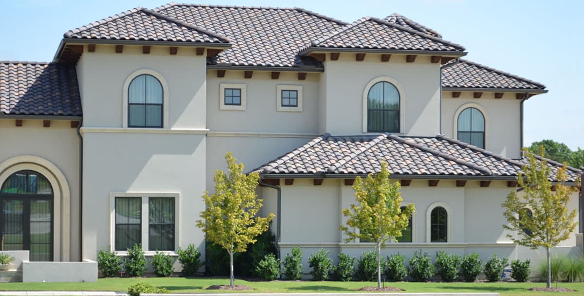 Mediterranean style house plan exterior with tile roof, arched windows, and decorative eaves.