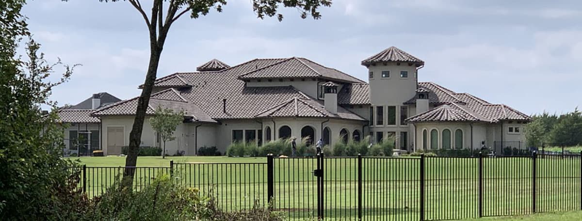 Mediterranean-style house plan exterior with a prominent tower, tile roof, arched windows, and multiple gables.