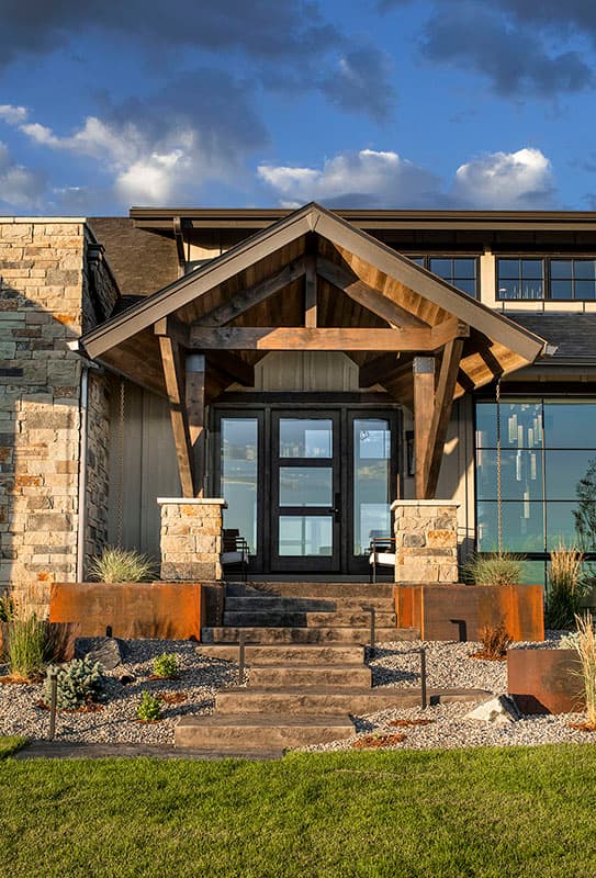 House plan exterior with stone accents, prominent wood-beamed gable entry, and multi-pane glass doors.
