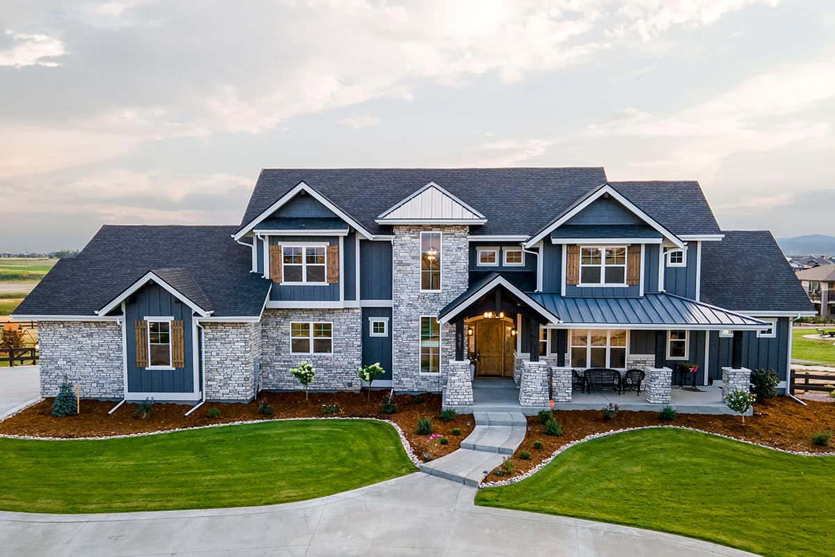 House plan exterior. Two-story, Craftsman-style home with stone and siding facade, covered front porch, multiple gables, and wood shutters.