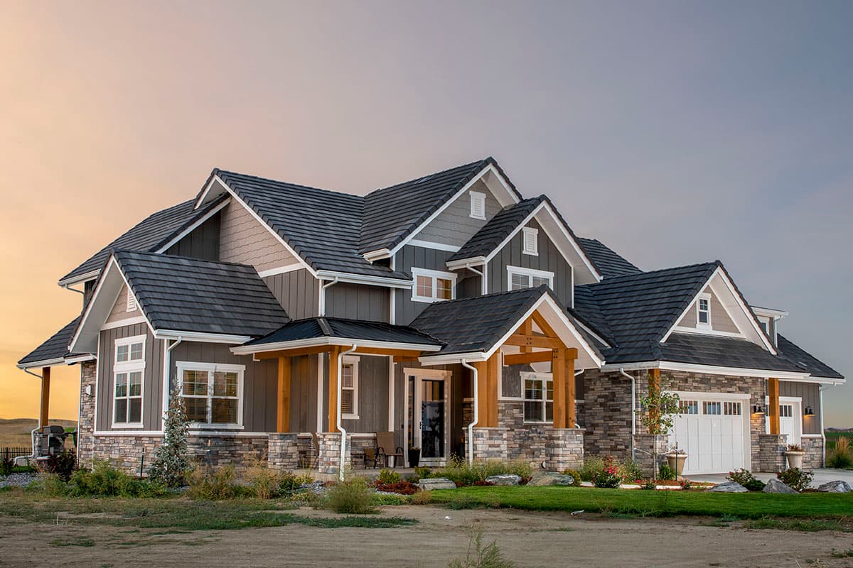 House plan exterior. Two-story Modern Farmhouse with stone accents, exposed timber framing on porch, and multiple gables.