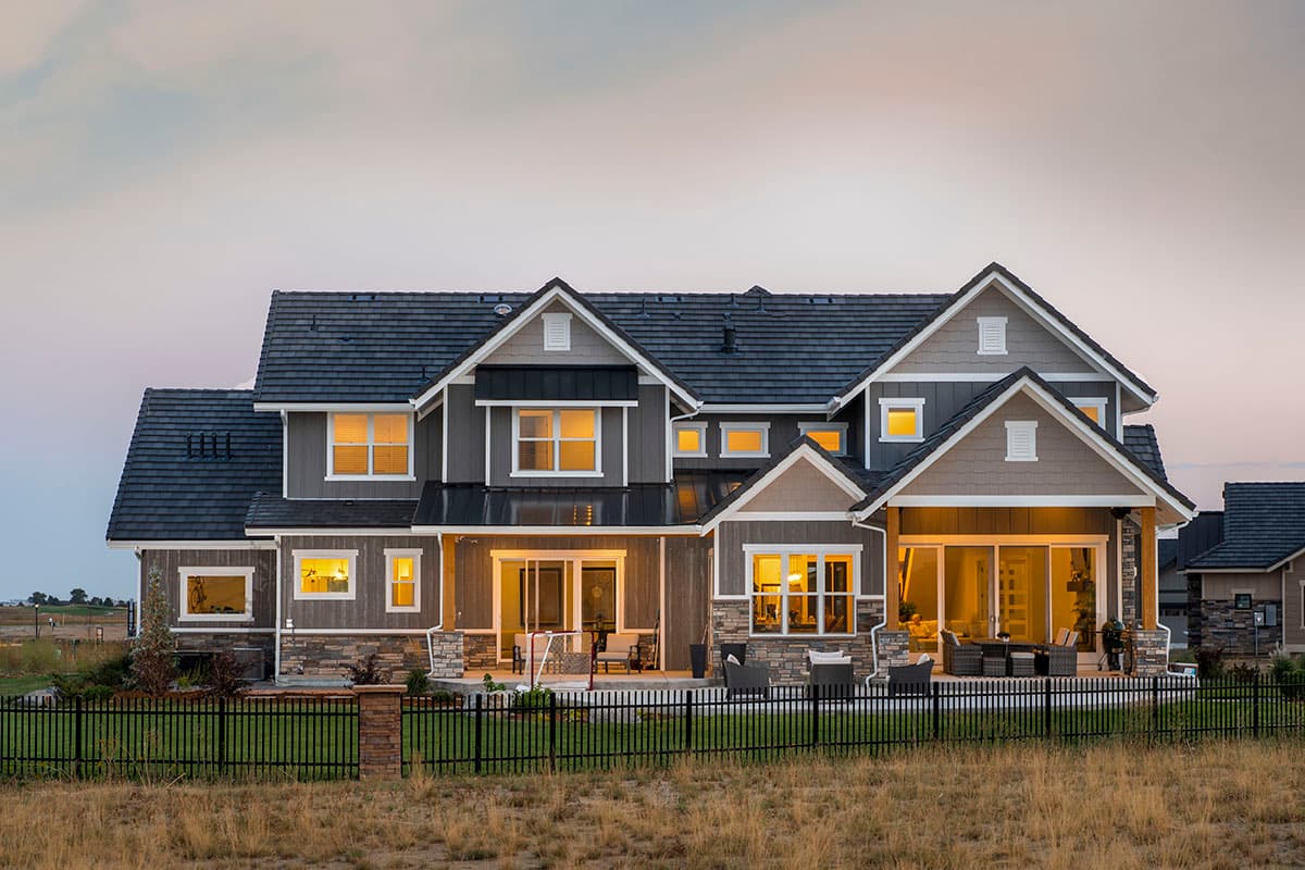 Two-story house plan exterior with multiple gables, dormers, covered porch, and stone accents.