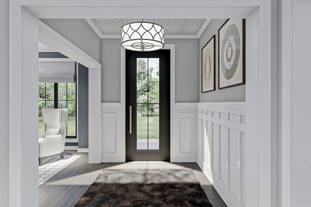 Interior view of a house entryway with wainscoting, geometric ceiling detail, and a black door with glass.