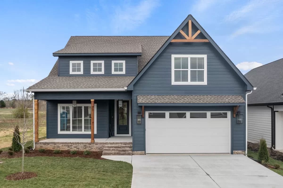 Modern Farmhouse style house plan exterior with blue siding, gabled dormers, covered porch, and a side-entry garage.