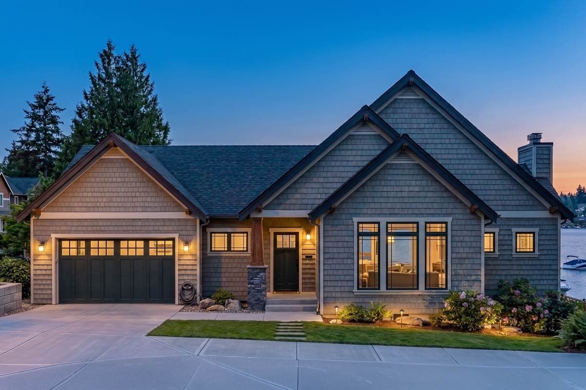 House plan exterior. Craftsman style, one story, with gabled roof, garage, and front porch. Features include a stone accent and multiple windows.