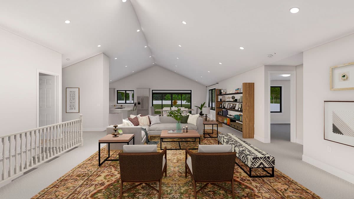 Open concept living area with vaulted ceiling, kitchen with island, and dining area with large windows.