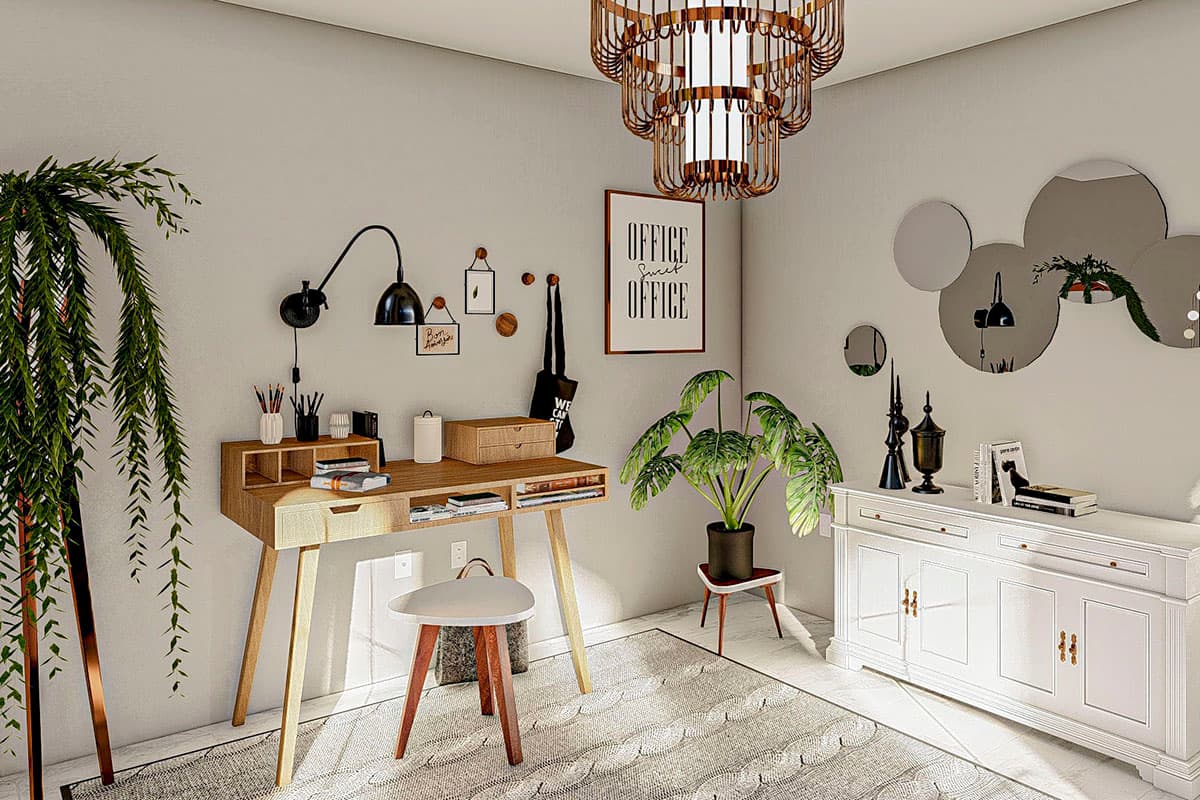Home office with wooden desk, stool, wall lamp, large plant, and white credenza with decorative mirrors.