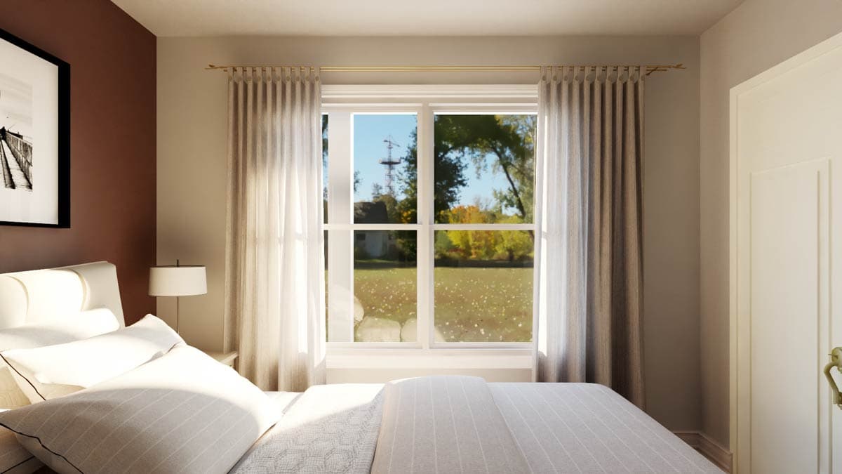 Bedroom interior with large window, bed, and art on accent wall.