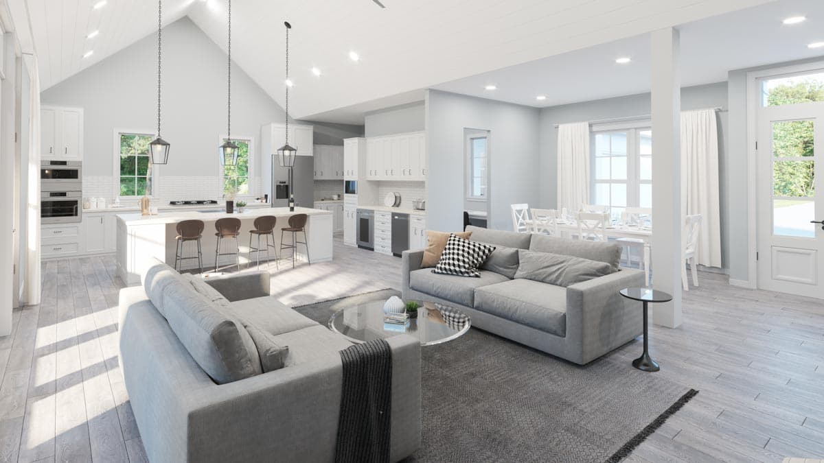Open concept living area with vaulted ceiling, kitchen island with bar stools, living room with sofas, and dining area.