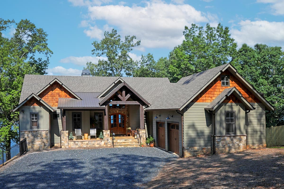 House plan exterior featuring Craftsman-style elements, multiple gables, a covered porch, and a side-entry garage. One-story house with shake siding.