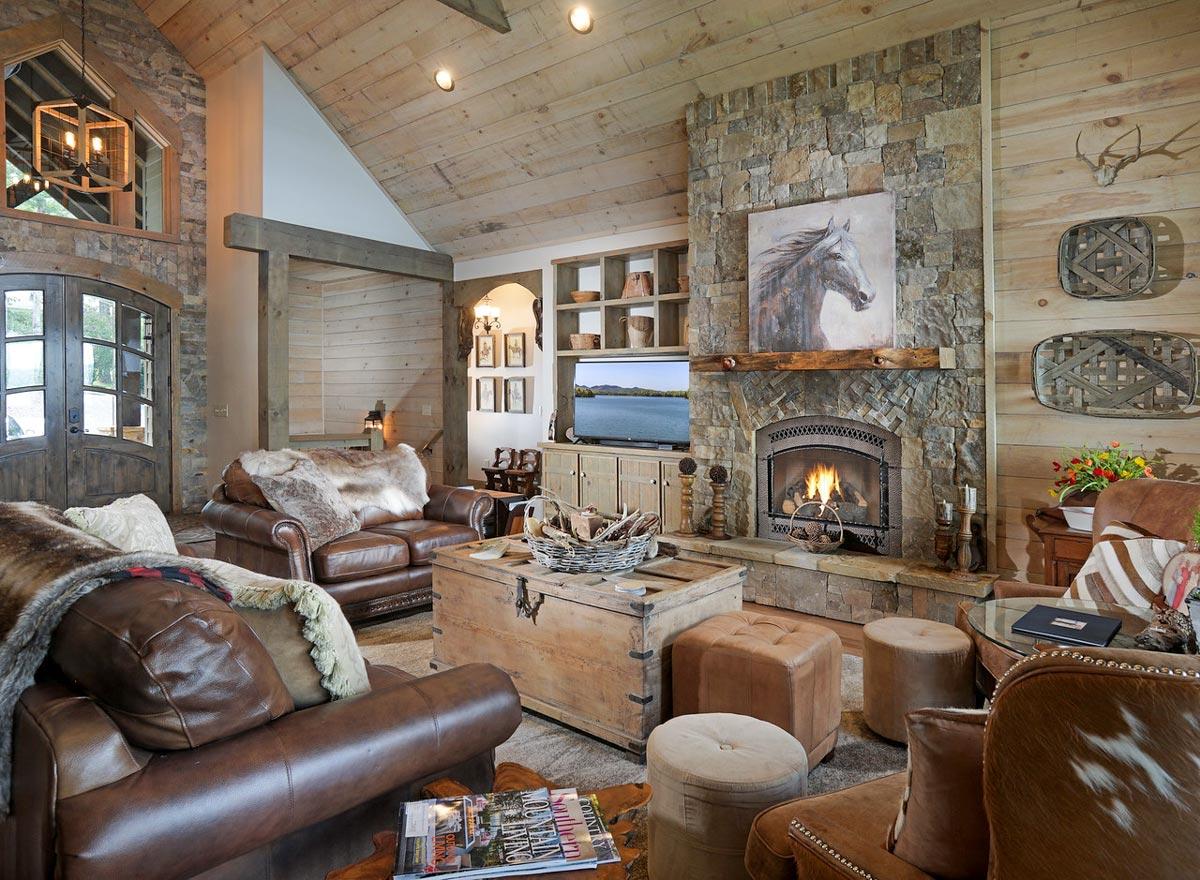Great room interior featuring a stone fireplace, vaulted wood-paneled ceiling, and leather seating.